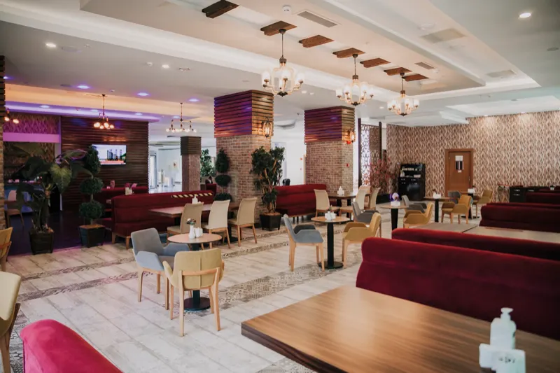 The restaurant's seating area: tables, colourful chairs and pendant chandeliers
