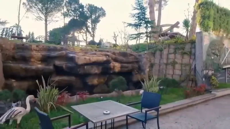Şelale Park'ta kaya şelalenin önünde bahçe masası